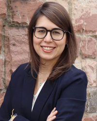 A professional woman with glasses and a blazer